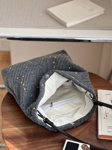 Detail view of the gray wool tweed tote bag with interior zipper pocket and magnetic buckle