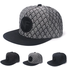 Detail of grey diamond pattern and black baseball cap with embroidered circular NF logo