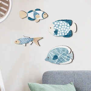 Dettaglio di quattro pesci decorativi in legno in stile nautico blu e bianco mediterraneo