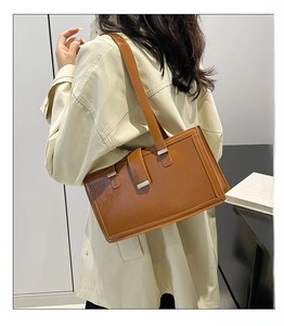 Detail einer braunen Vintage-Schultertasche mit eleganter silberner rechteckiger Schnalle