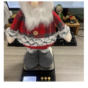 Detail showing Christmas Santa doll weighing approximately 344.5g on a digital scale