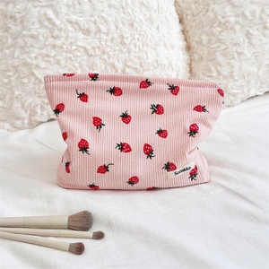 Vue détaillée de la pochette en velours côtelé rose avec motif fraise et fermeture