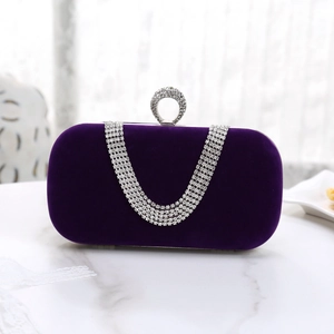 Detail of deep purple velvet clutch with rhinestone chain tassel and crystal buckle