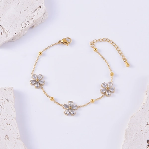 Elegant gold-plated stainless steel bracelet with zircon flower charms on white stone