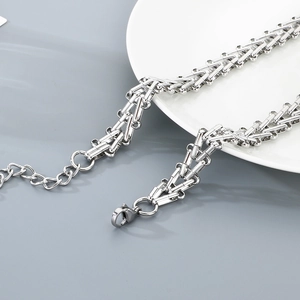 Detail of a 12mm geometric chain necklace with lobster clasp on a white plate