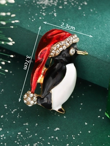 Macro detail of Christmas penguin brooch with enamel finish and sparkling rhinestones