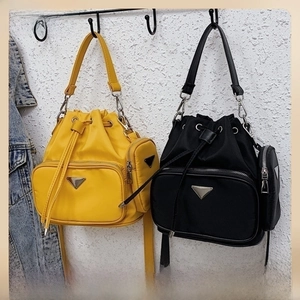 Close-up of nylon bucket bag featuring a drawstring closure and mini coin purse detail