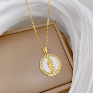 Luxurious gold medallion necklace featuring shell relief and pearl halo on white silk fabric