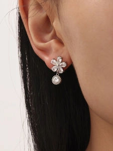 Gros plan de boucles d'oreilles fleurs étincelantes avec pendentifs en cristal