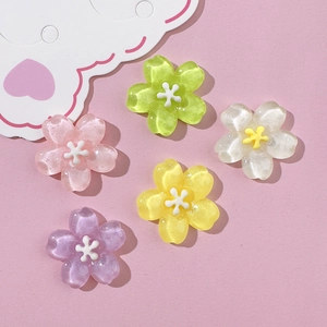 Macro detail of five colorful glitter resin flower charms for DIY crafts and accessories