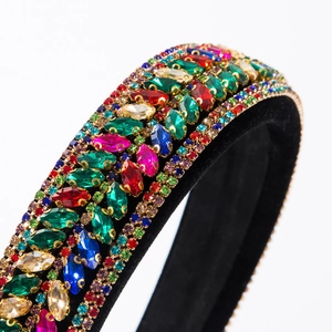 Macro detail of bohemian headband with colorful gemstones and rhinestones on black velvet
