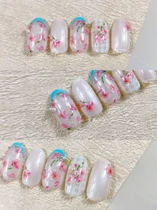 Détails de faux ongles fleurs de cerisier roses avec perles et pointes French bleues