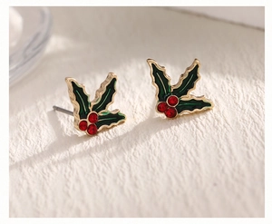 Macro detail of holly leaf Christmas earrings with green enamel and red rhinestones