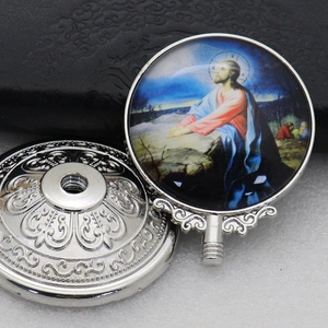 Detailed view of a silver religious pendant with Jesus prayer icon on black leather