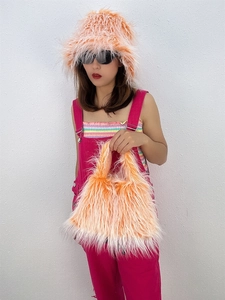 Detail of bright orange faux fur bucket hat and matching plush handbag for winter