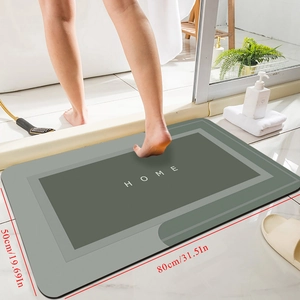 Detail of grey diatomite bath mat with HOME text showing 80x50cm dimensions and absorbency