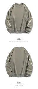 Détail du sweat taupe oversize avec des empiècements contrastés gris et blancs sur la manche