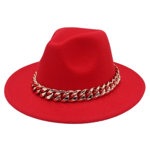 Macro shot of red felt fedora hat featuring a chunky decorative gold acrylic chain