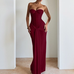 Detail of dark red strapless evening gown featuring corset bodice and silk-like fishtail skirt
