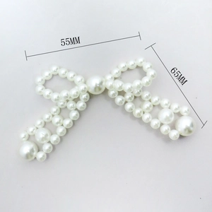 Detail view of pearl bow hair accessory with 55mm and 65mm size dimensions shown