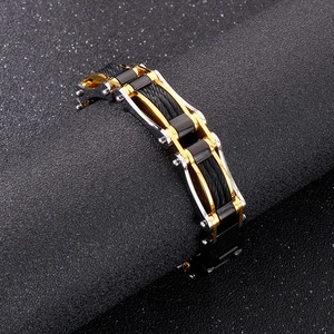 Détail d'un bracelet industriel pour homme en acier avec câble torsadé or noir argent