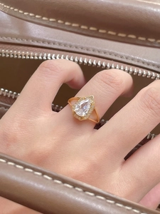 Detailed view of S925 silver pear-cut diamond ring on hand with vintage gold trim