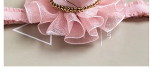 Detailed view of pink ruffled silk headband with elegant gold and black braided trim