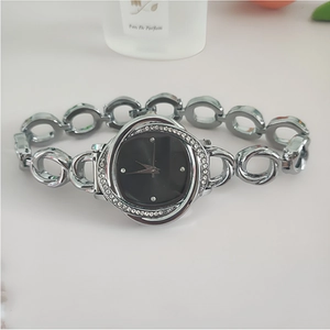 Detail view of silver floral diamond-encrusted bezel with minimalist black dial watch