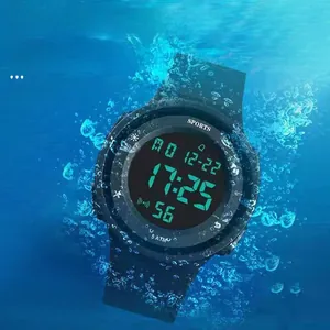 Macro shot of waterproof digital sports watch submerged in blue water with bubbles