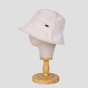 Close-up of cream white lace sun hat featuring breathable woven texture and metal logo