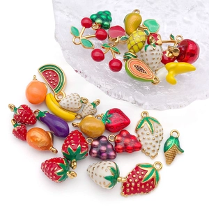 Detail of assorted enamel fruit and vegetable pendants on a textured glass tray
