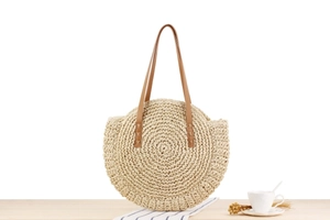 Detail of round paper rope woven beach bag with brown faux leather handles and zipper