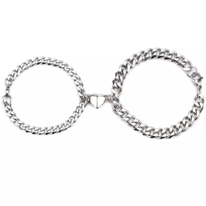 Silver Cuban chain couple bracelets with heart-shaped magnetic clasp on white background