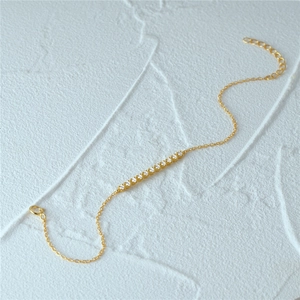 Detailed close-up of a delicate gold S925 silver bracelet with sparkling pavé crystals