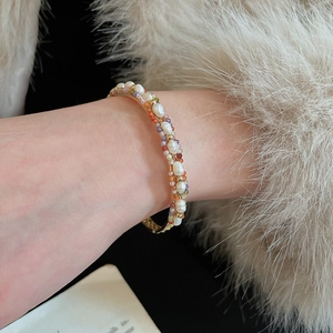 Détail du bracelet manchette avec perles naturelles et pierres précieuses colorées sur métal doré
