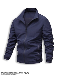 Detail of dark blue windbreaker jacket featuring breathable mesh lining and secure zippers