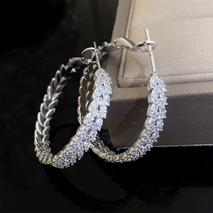 Detail of silver hoop earrings with woven texture and micro-pave cubic zirconia stones