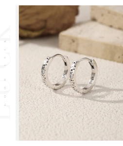 Close-up of S925 sterling silver hoop earrings with star engraving and Moissanite stone