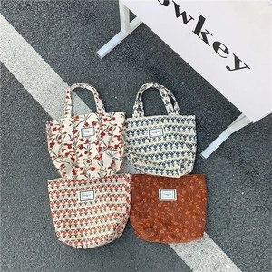 Corduroy tote bags with vintage floral patterns and woven labels in a four-pack display