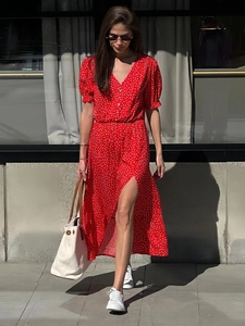 Red V-neck polka dot midi dress with puff sleeves and side slit shown in a walking pose