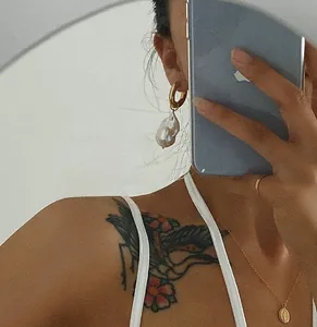 Baroque pearl earrings in 18K gold shown on model with mirror selfie aesthetic style