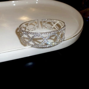 Macro shot of silver-plated open cuff bracelet featuring geometric zircon hollow patterns