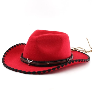 Detail of red western cowboy hat with silver bull skull metal piece and leather fringe
