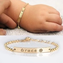 Detail of personalized gold baby bracelet with Grace engraving and floral pattern