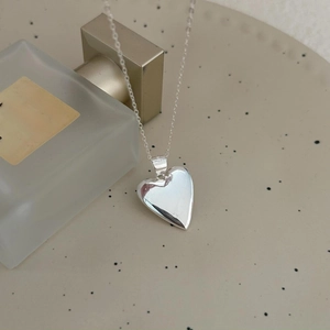 Minimalist sterling silver heart necklace with a polished pendant on a delicate chain