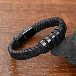 Close-up of black braided leather bracelet with magnetic buckle on dark stone