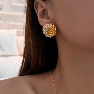Detailed shot of vintage gold shell earrings with pavé cubic zirconia gemstones