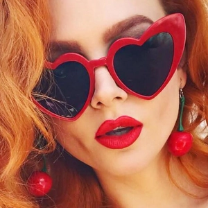 Close-up of red heart sunglasses and cherry earrings set for women fashion