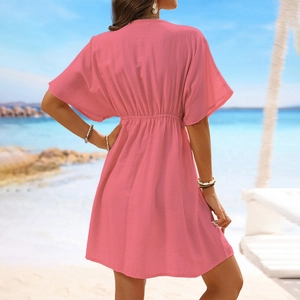 Detail of pink beach cover-up with elastic waist and textured fabric on beach