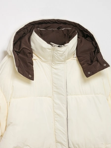 Detail of hooded padded coat showing contrast brown lining and metal snap buttons